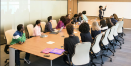 Femme menant une présentation devant des collaborateur en salle de réunion