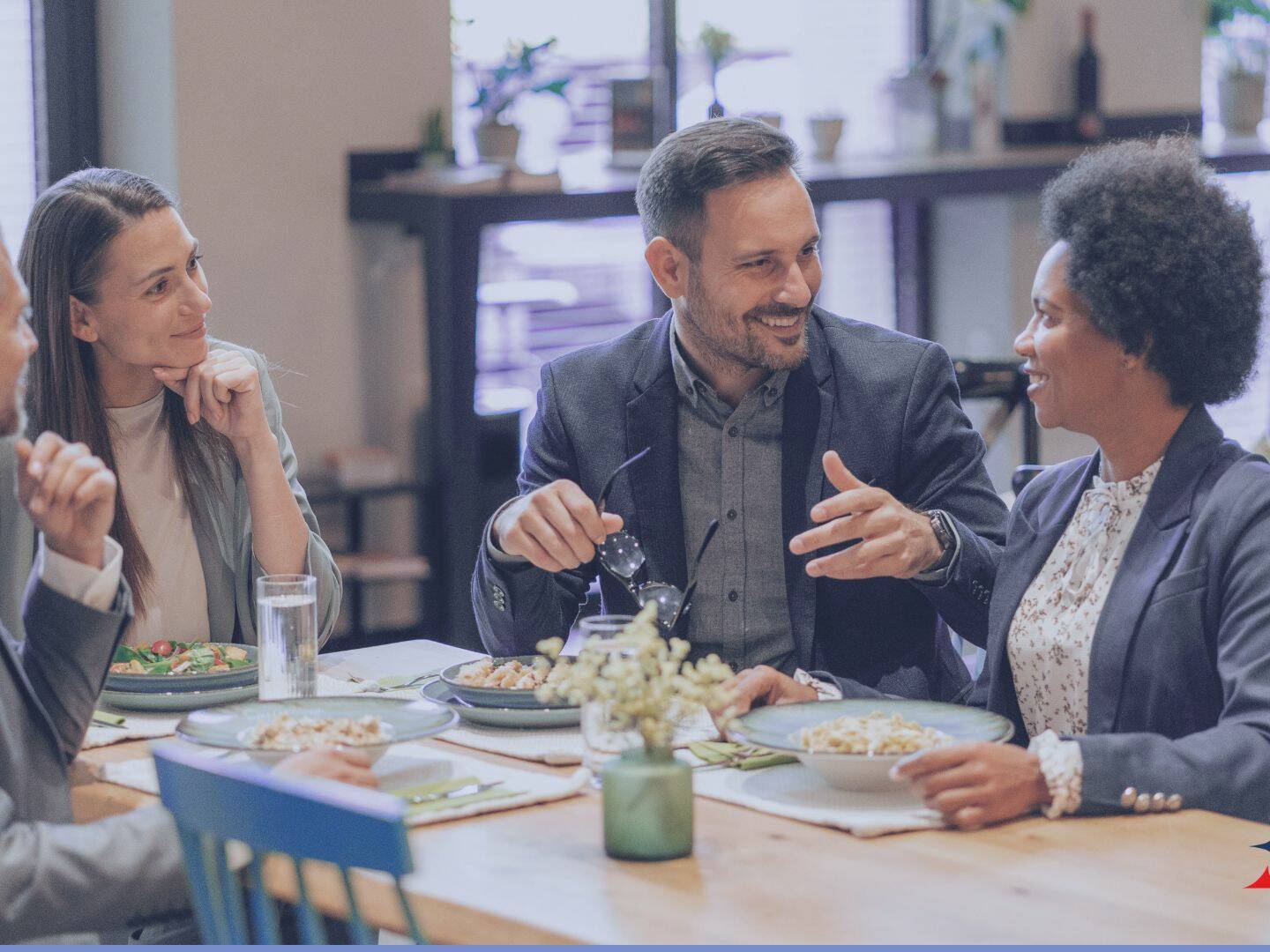 4 people sitting at a table having lunch and talking