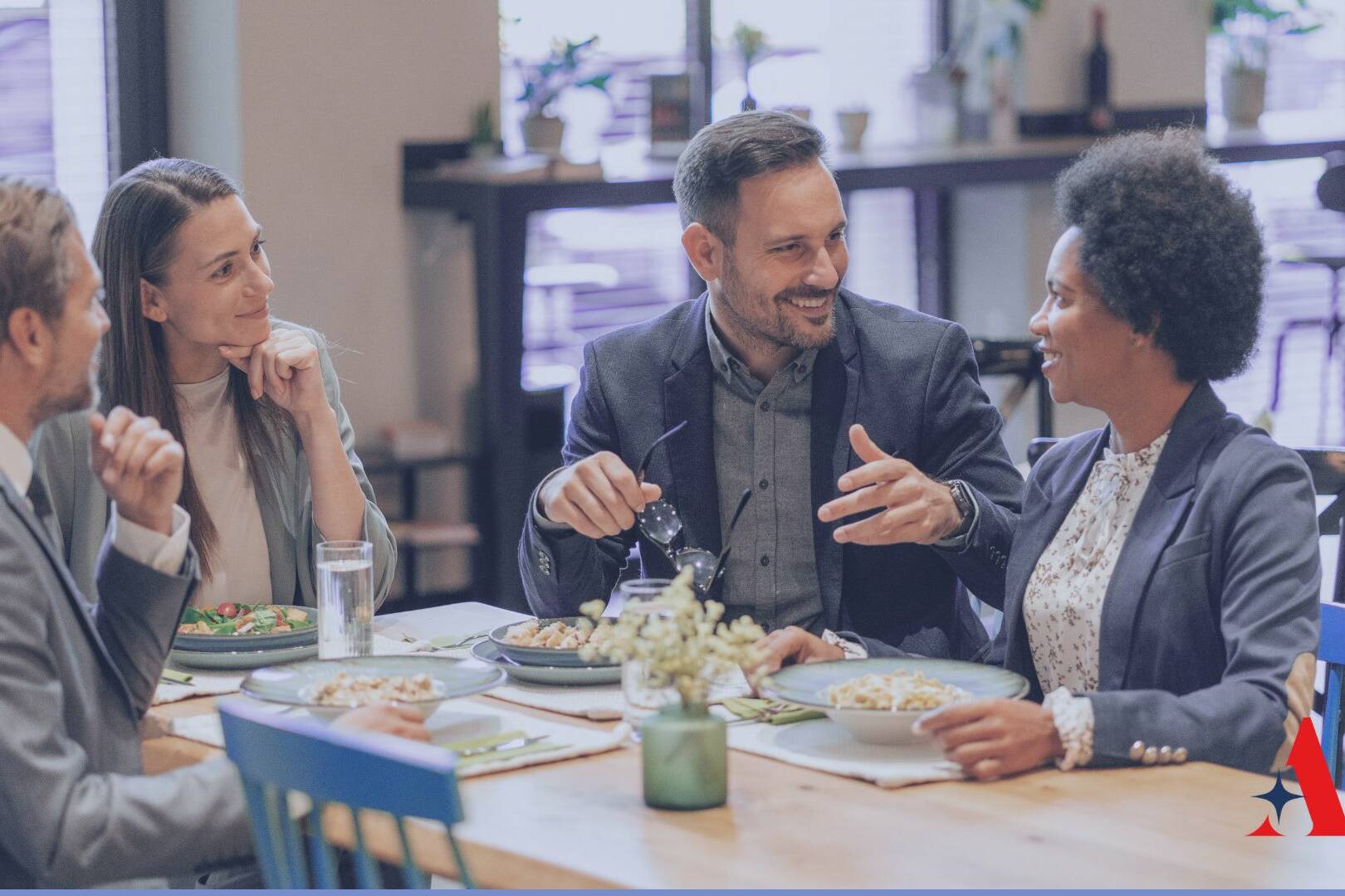 4 people sitting at a table having lunch and talking