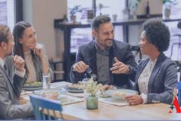 4 people sitting at a table having lunch and talking