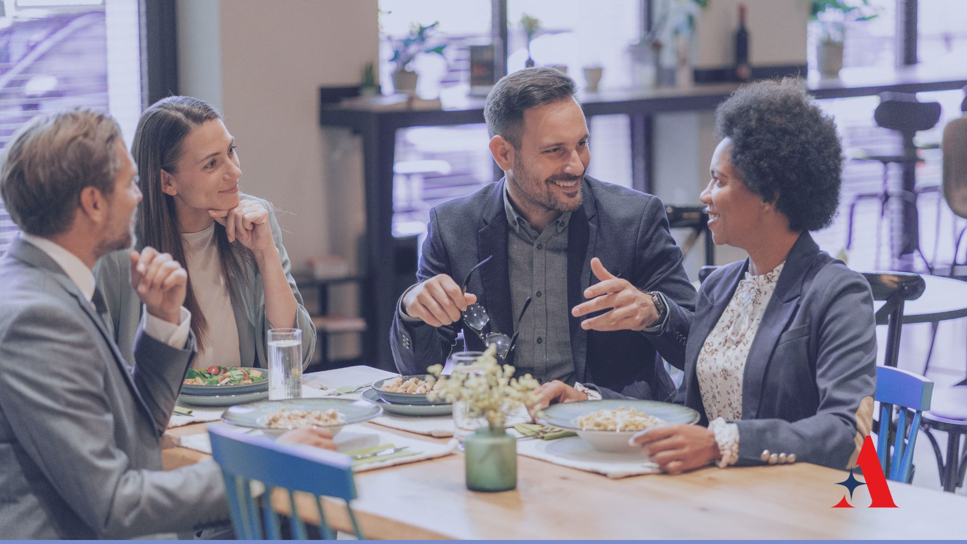 4 people sitting at a table having lunch and talking
